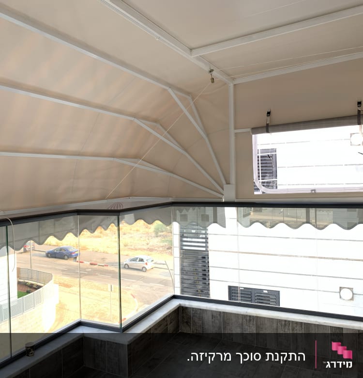 מרפסת עם סוכך בד בהיר ומסגרת מתכת לבנה